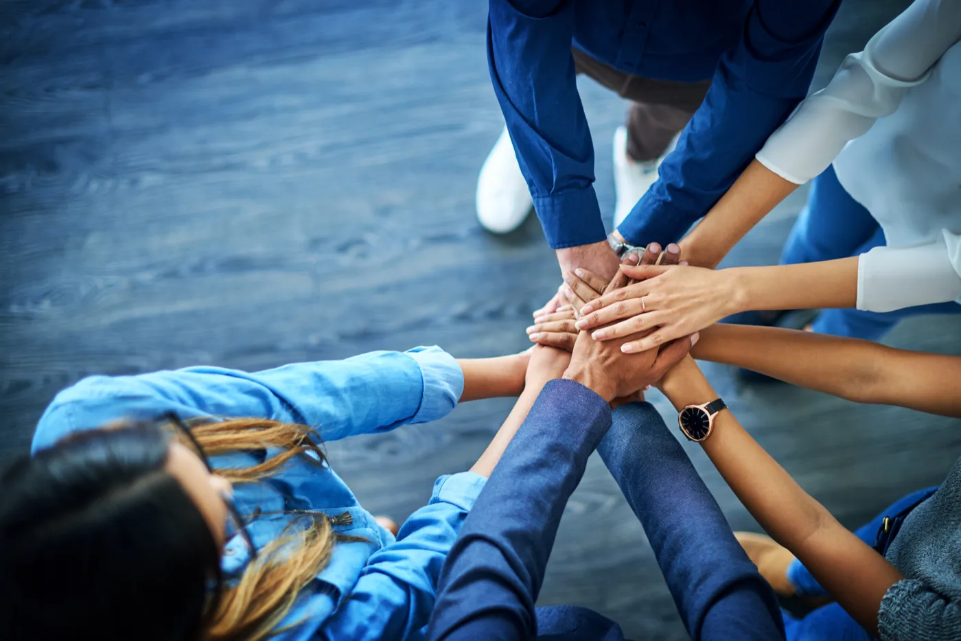 Gould Agency team members putting their hands together